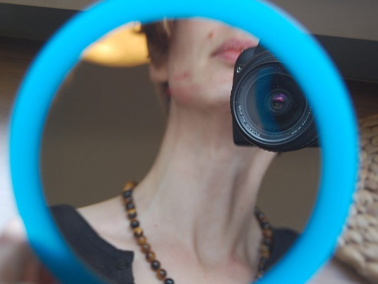 Frau mit Kamera im Spiegel