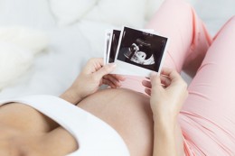Schwangere Frau betrachtet Ultraschallbild