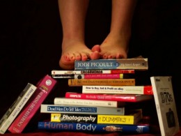 Nackte Füße auf Bücherstapel