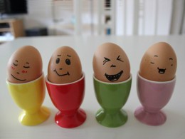 Vier Eier mit Gesichtern in Eierbechern