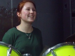 ein fröhliches Mädchen am Schlagzeug