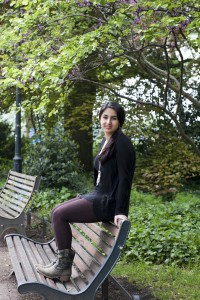 Zu sehen ist Marjan Amiri, eine Flüchtlingsfrau, während sie auf einer Bank sitzt.