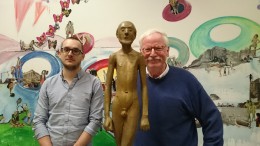 zwei Männer neben einer Bronzefigur