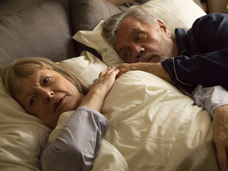 älteres Ehepaar liegt im Bett