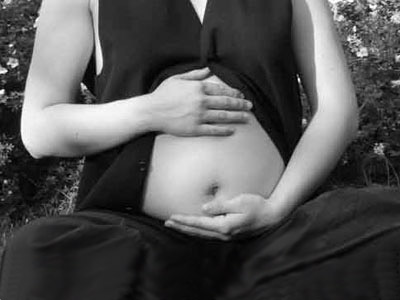Geburt, Hände halten schwangeren Bauch