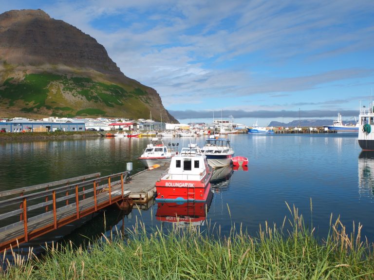 Fjord in Island mit rotem Boot