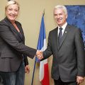 Frau und Mann geben sich vor französischer Flagge die Hand