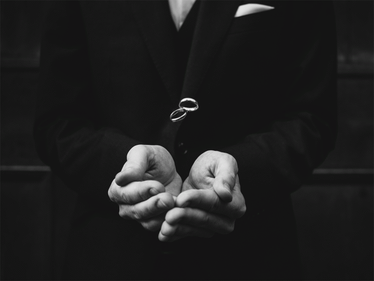 Schwarz-weiß Bild auf dem zwei Hände zwei Ringe auffangen