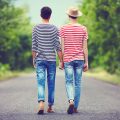 Junges homosexuelles Paar geht Hand in Hand auf einer Straße