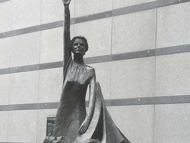 Europa-Statue, Frau hält mit erhobenem Arm ein €-Zeichen