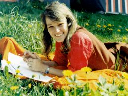 altes Farbfoto von Hannah in der Sonne auf einer Blumenwiese liegend