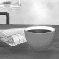 Ein Becher mit Kaffee steht auf einem Tisch. Daneben liegt eine Zeitung. Im Hintergrund sieht man zwei lila Stuhllehnen und einen Ausschnitt eines Fensters in schwarz weiß