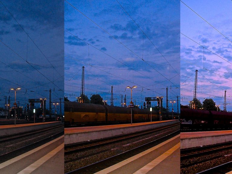 Drei Fotografien von Gleis 1 am Bremer Bahnhof aus zu unterschiedlichen Tageszeiten nebeneinander. Die Bilder werden zunehmend heller, die Hauptfarben des Himmels sind lila blau.