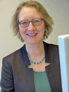 Portrait einer Frau mit grauem Blazer und Brille