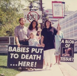 Erwachsene und ein Kind halten Schilder gegen Abtreibung hoch und protestieren gegen Schwangerschaftsabbrüche