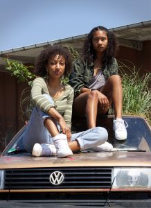 Zwei Mädchen sitzen auf dem Auto
