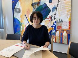 Senatorin Claudia Bernhard unterzeichnet am Schreibtisch Verwaltungsvereinbarung