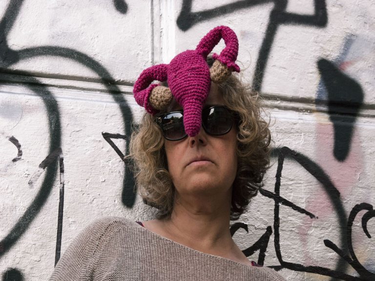 Künstlerin Katrin Bretschneider mit selbstgehäkelter Gebärmutter an der Stirn