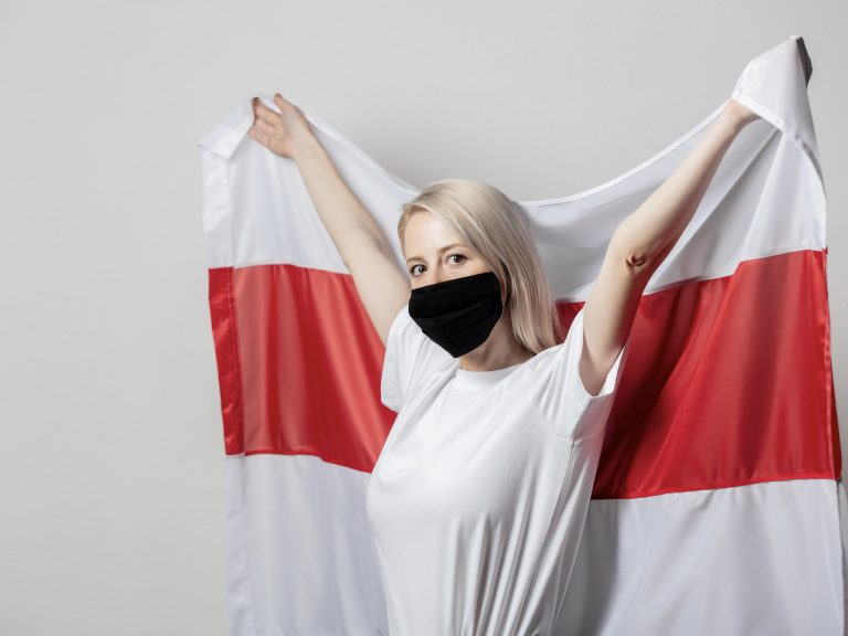 Frau mit einer Maske und der weiß rot weißen Flagge von Weißrussland / Belarus
