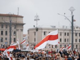 Bild von der Demonstration in Minsk mit der Flagge weiß rot weiß im Vordergrund
