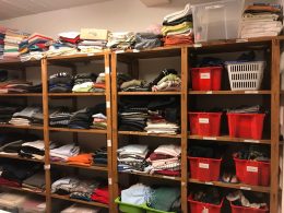 Eine Kleiderkammer mit vielen Regalen und Kleidungsstücken
