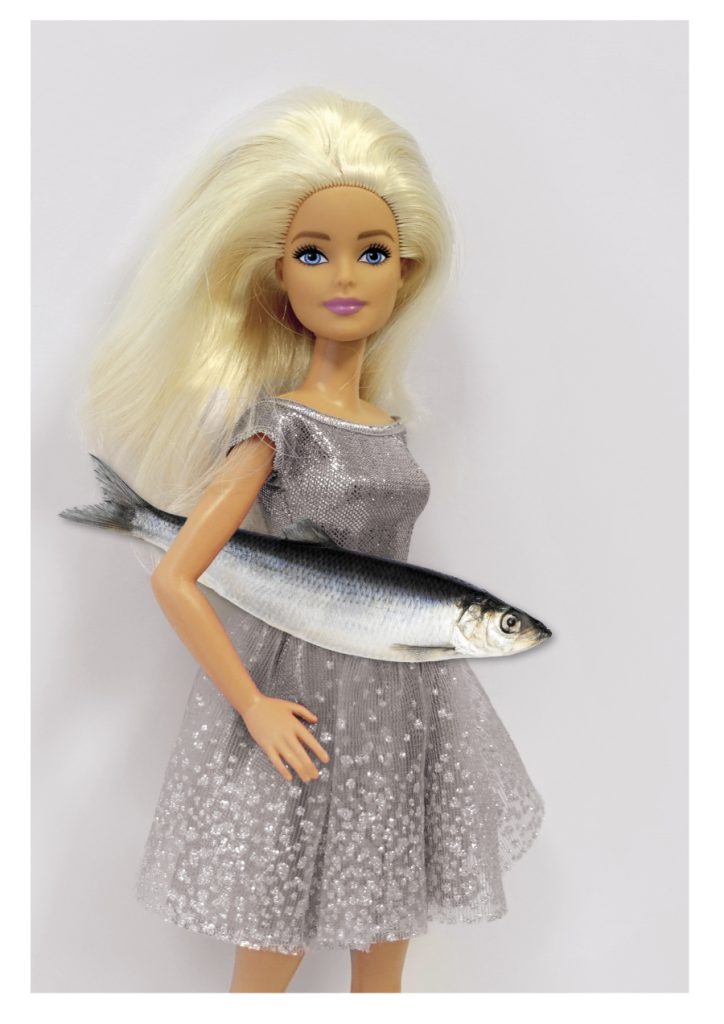Blonde Barbiepuppe mit einem Fisch unter der Hand. Collage und Titelbild des Plakates zur Ausstellung "Busy Girl Barbie macht Karriere" im Ostfriesischen Landesmuseum Emden