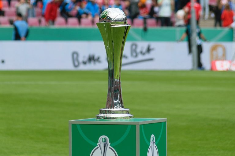 Nahansicht des DFB Pokals der Frauen im Hintergrund ein Spielfeld