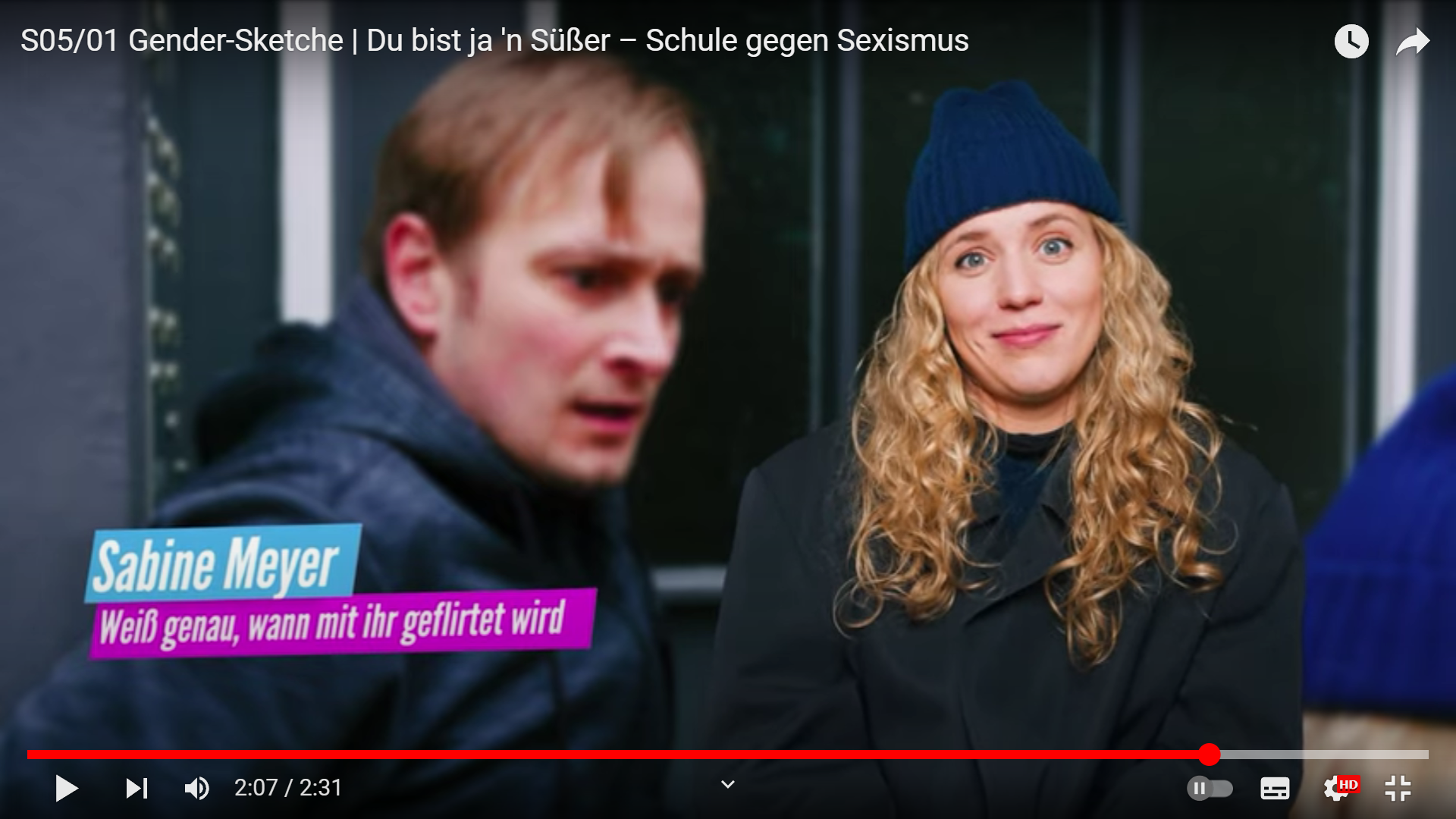 Standbild aus der Staffel fünf, Episode eins der Gender Sketche. Zeigt eine blonde Frau namens Sabine Meyer im Interview. Ihr Untertitel besagt, Weiß genau, wann mit ihr geflirtet wird.