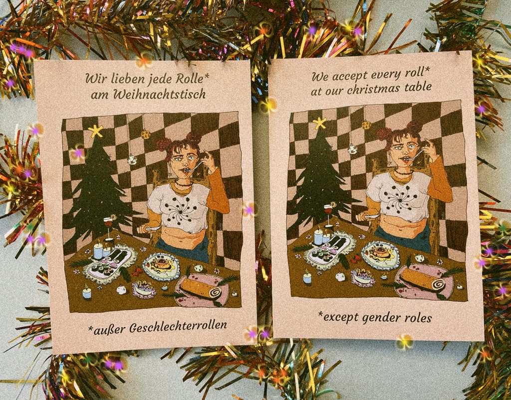 Zu sehen sind die deutsche und englische Version der frauenseiten Weihnachtskarte. Hinter den Karten liegt buntes Lametta.