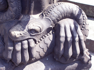 Steinskulptur am Bremer Dom: Schlange beisst in eine Löwenpranke