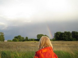 Regenbogen mit Kind im Vordergrund